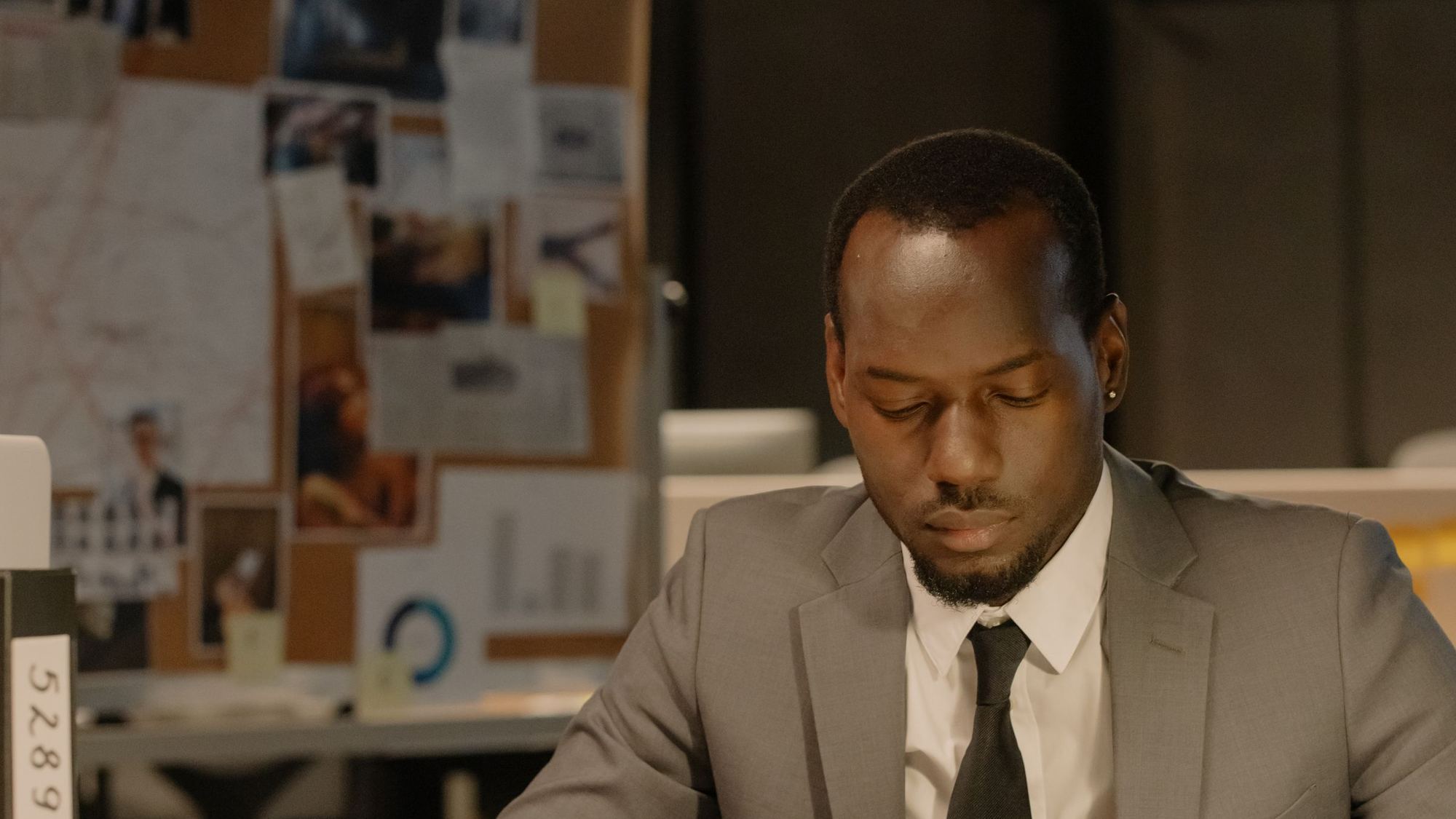 Man in a suit reviewing documents at his desk